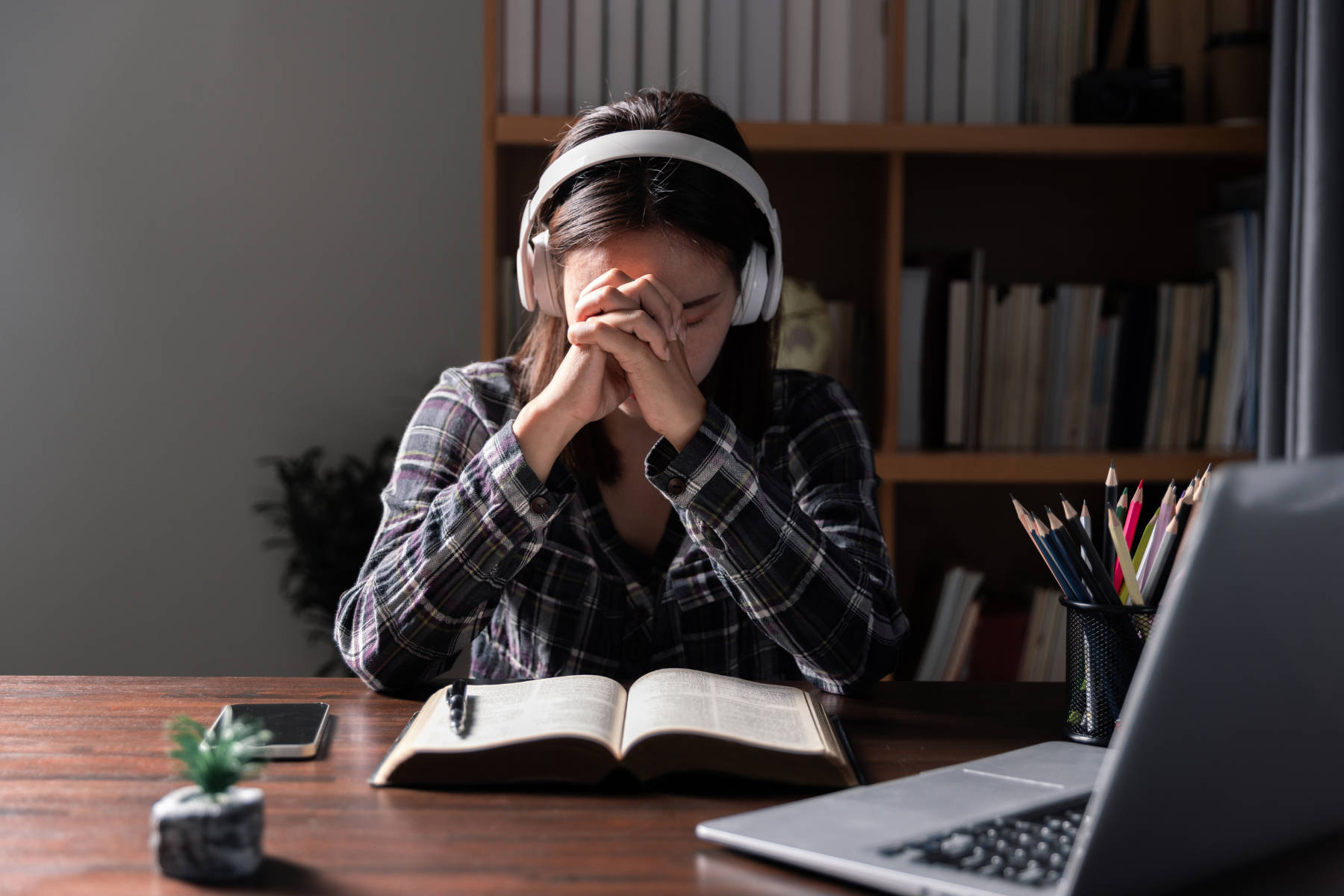 Christian online technology concept. Hands praying of christian with digital computer laptop, Online live church for sunday service. Asian catholic man are reading Holy bible book and online study.